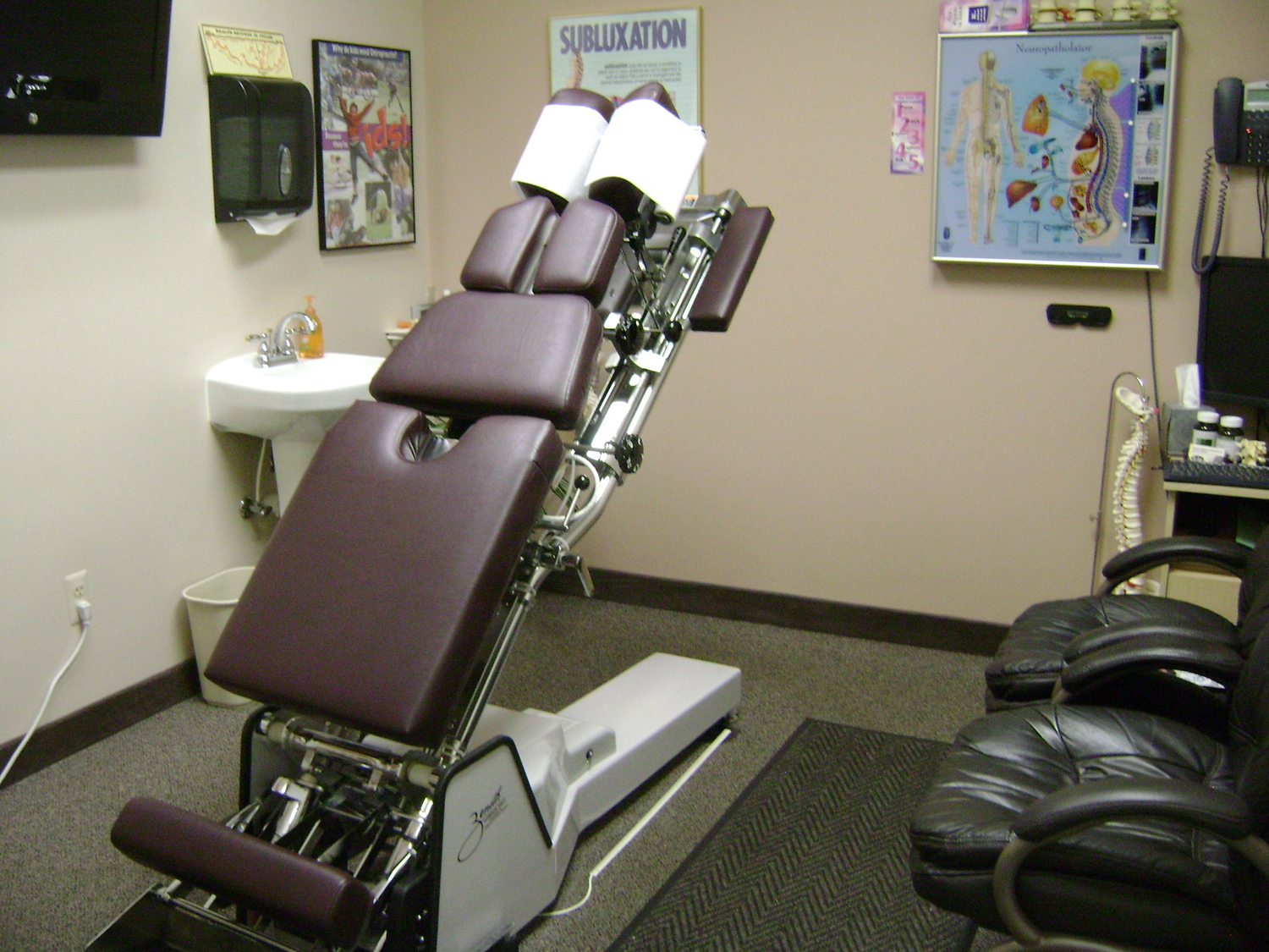 Gallery Photo of Spinal Adjustment Room.  The thompsom Tables has sections which shift to reduce the Spinal Subluxations in the spine.